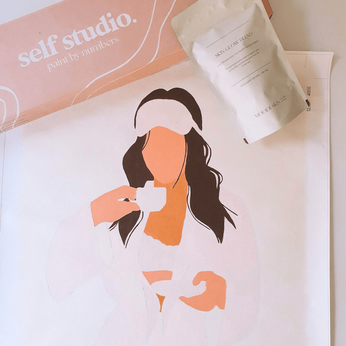 paint by numbers kit of girl in robe with cup of tea and skin glow tea blend